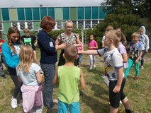 Dzieci wykonują zadania na dworze w grupach