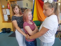 Trzy dziewczynki stoją trzymając się za ręce