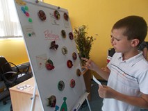 Chłopic stoi przy tablicy, na której widnieją zapisane pomysły na dbanie o środowisko