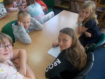 Dzieci siedzą przy stolikach podczas prac w grupach