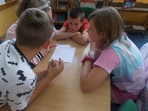 Dzieci siedzą przy stolikach podczas prac w grupach