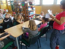 Dzieci siedzą przy stolikach podczas prac w grupach