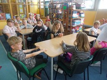 Dzieci siedzą przy stolikach podczas prac w grupach