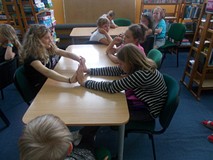 Dzieci siedzą przy stolikach podczas prac w grupach