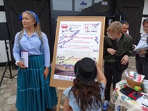 Aktorzy uczestniczący w akcji Narodowe Czytanie 2019 zgromadzeni przy plakacie składają pamiątkowe a