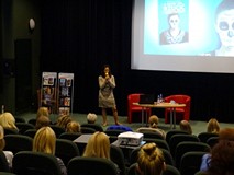 Małgorzata Kardzis podczas spotkania. Na pierwszym planie widać zgromadzoną publiczność.