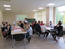 Młodzież biorąca udział w warsztatach z socjolożką Hanną Kroczak. Uczestnicy siedzą przy stoliku.