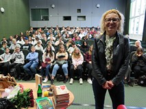 Joanna Jagiełło stoi po prawej stronie zdjęcia. W tle, za nią uczestnicy akcji Nastolatki w Bibliote