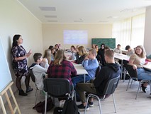 ż biorąca udział w warsztatach z socjolożką Hanną Kroczak. Uczestnicy siedzą przy stoliku.
