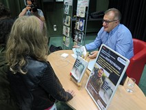 Marcin Kostrzyński rozdaje autografy po zakończonym spotkaniu w Koszalińskiej Bibliotece Publicznej.