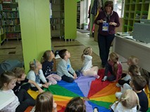 Dzieci słuchają bibliotekarki opowiadającej o zwierzętach