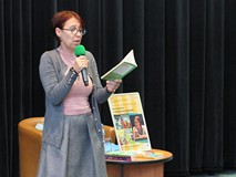 Małgorzata Strekowska-Zaremba czyta na głos przez mikrofon fragment ksiązki swojego autorstwa.
