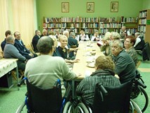 uczestnicy spotkania siedzą przy stole i rozmawiają
