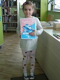 Mała Madzia pokazuje swój Dyplom Małego Czytelnika