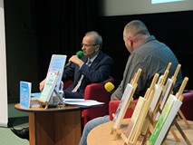 Od lewej: Eugeniusz Żuber, Piotr Pawlikowski. Międzynimi stolik z plakatemi książkami. Na pierwszym 
