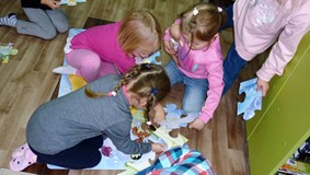 Dzieci układają bardzo duże puzzle