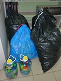 Cztery wielkie worki i dwie duże butelki wypełnione nakrętkami