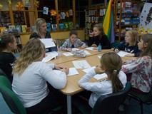 Dzieci siedzą przy stole i wykonują prace plastyczną