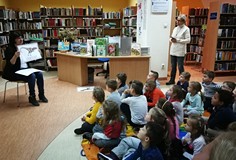 Przedszkolaki oglądają dinozaury na kolorowych planszach