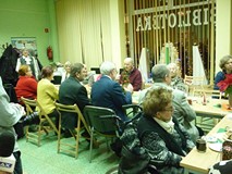 na zdjęciu zebrali siedzą przy stołach i rozmawiają