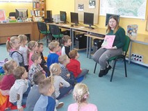 Bibliotekarka pokazuje dzieciom książki o smokach, księżniczkach i rycerzach