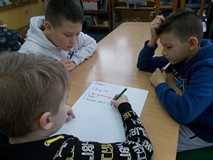 Dzieci pracują w grupie, wypisując najważniejsze zasady kultury