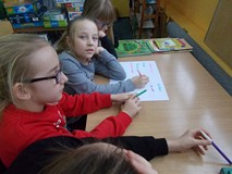 Dzieci pracują w grupie, wypisując najważniejsze zasady kultury