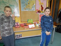 Dwóch chłopców pozuje do zdjęcia z pracami plastycznymi