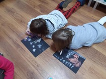 Zimowe pejzaże w Dolinie Muminków- malowanie na podłodze na czarnych kartkach