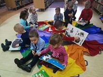 Dzieci oglądają książeczki z BIBLIOTECZKI MALUCHA