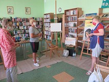 Na tle regałów z książkami stoją uczestniczki warsztatów. Od lewej Maria Szlachcikowska, Teresa Dąbr