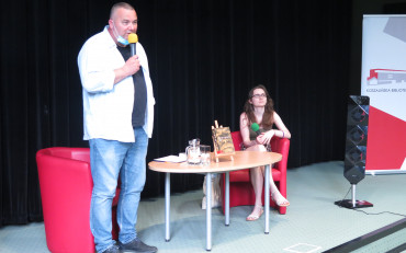 Od lewej: Przy stoliku stoi redaktor Piotr Pawłowski, dalej przy tym samym stoliku siedzi...