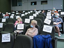 Pobliczność zgromadzona na spotkaniu z Cezarym Harasimowiczem siedzą w maseczkach, co drugie siedzen