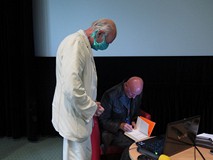 Cezary Harasimowicz składa dedykację dla uczestnika spotkania. Czytelnik stoi z jego lewej srtony z 