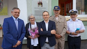 Pamiątkowe zdjęcie na tle odsłoniętej tablicy. Od lewej: Prezydent Koszalina Piotr Jedliński, Anna B