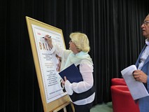 Radna Bożena Kaczmarek podpisuje się na plakacie