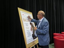 Przewodniczący Rady Miejskiej Jan Kuriata podpisuje się na plakacie