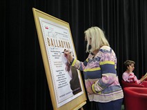 Radna Krystyna Kościńska podpisuje się na plakacie