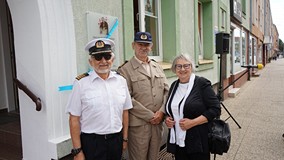 Na zdjęciu: Dzieci Gracjana Bojara-Fijałkowskiego pod tablicą upamiętniającą ojca na budynku koszali