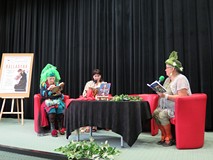 Na zdjęciu: za stołem siedzą trzy panie w kolorowych kapeluszach i czytają fragmenty Balladyny Juliu