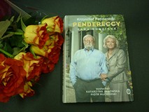 na zdjęciu na czarnym tle kwiaty oraz książka Pendereccy