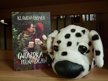 na zdjęciu książka Klaudia Bianek Gwiazdka pełna życzeń. Obok maskotka białego pieska w czarne kropk