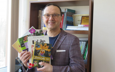 Dyrektor KBP, Dariusz Pawlikowski trzyma w rękach książki o kwiatach