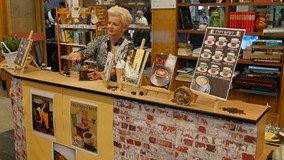 Bibliotekarka przygotowuje kawę mieloną w ręcznym młynku w czasie Włoskiej Nocy w Koszalińskiej Bibl