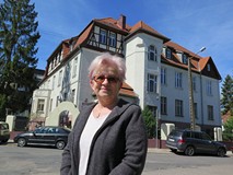 Iwona Sławińska stoi przed komisariatem przy ul. Jedności. Opowiada o nim na zaproszenie Koszaliński