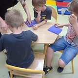 Chłopcy przy stole wykonujący maskotki