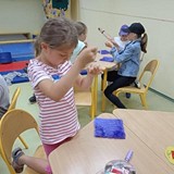 Dzieci przy słolikach szyjace swoje maskotki.