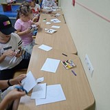 Dzieci siedzące przy stole, wycinajace szablony.