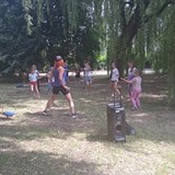 Dzieci i instruktorka tańczą w ogrodzie Zumbę.