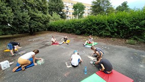 Dzieci rysuja kredą na placu